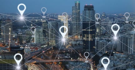 Picture of a city with a white network joining white location markers overlaid